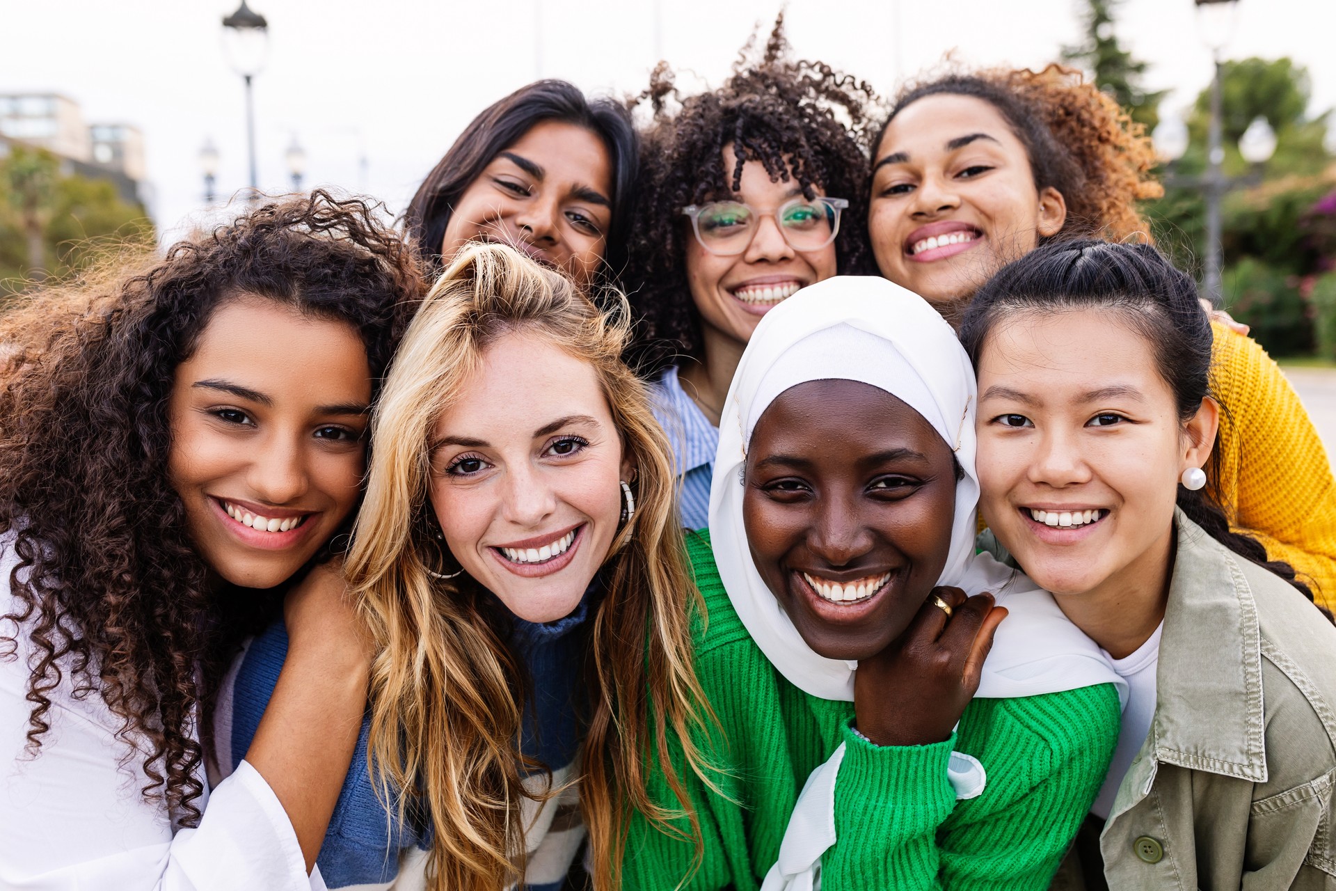 Portrait of young multiracial girls smiling at camera standing together outdoors